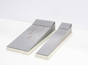 Layered necklace display on a velvet bust with subtle gold accents.