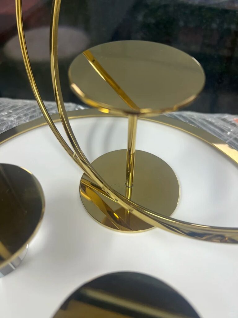 Close-up of a luxury display stand with a polished gold metal finish, showcasing an elegant design with sleek, reflective surfaces ideal for high-end retail displays.