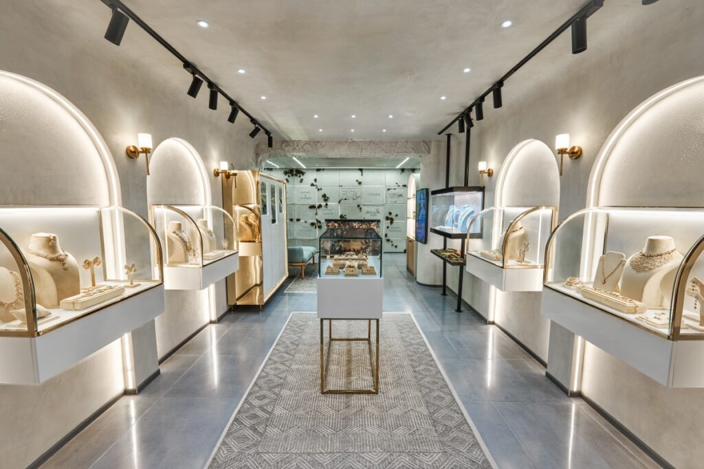 A luxury fashion brand creates a display with brass fixtures, velvety textures, and elegant lighting, signaling exclusivity and refinement in their retail store.