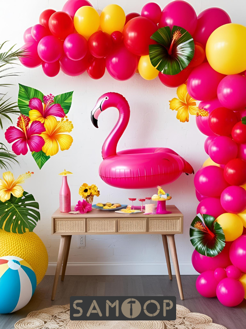 Tropical summer party display featuring a pink flamingo float, papaya-red and lemon-yellow balloon arch, tropical paper leaves, and hibiscus flowers on a bold backdrop.