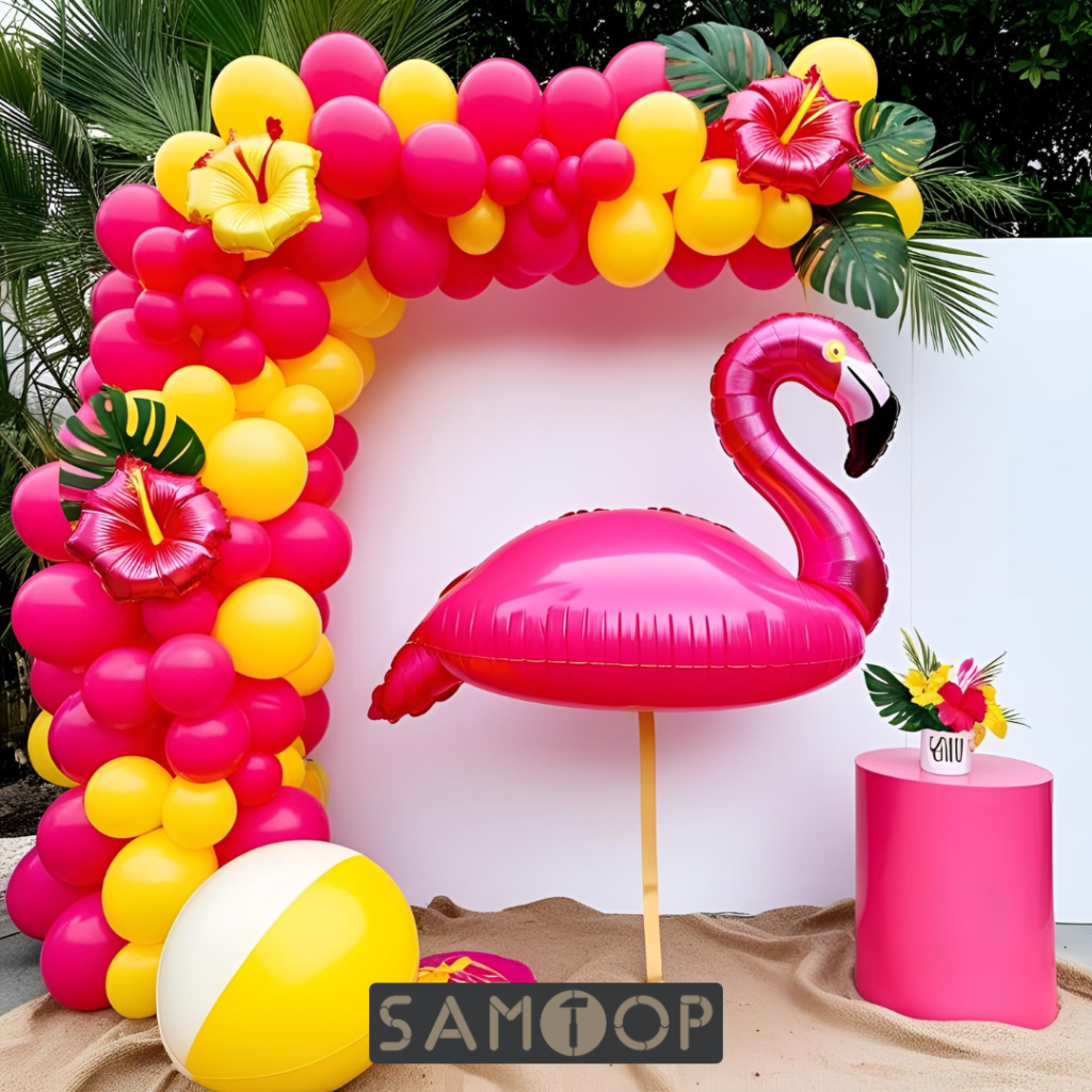 Tropical summer party display featuring a pink flamingo float, papaya-red and lemon-yellow balloon arch, tropical paper leaves, and hibiscus flowers on a bold backdrop.
