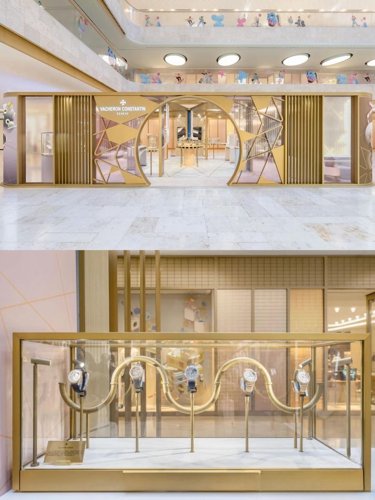 Watch display case featuring gold metal frames with transparent glass, showcasing luxury timepieces in a minimalist yet sophisticated retail environment.