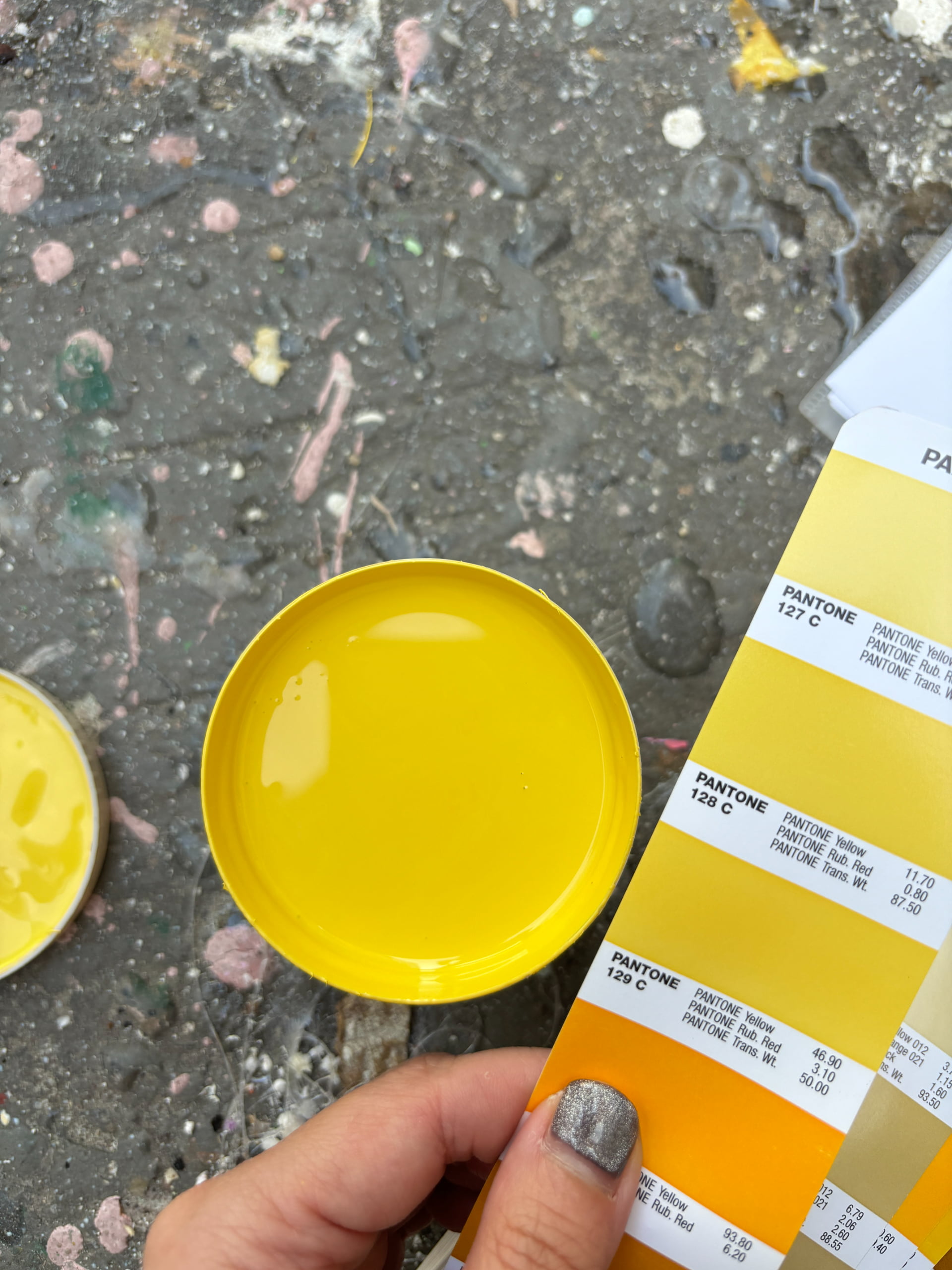 Factory QC team matching yellow paint against Pantone 127C and 128C color reference during prop production for the Netflix House Dallas Christmas installation