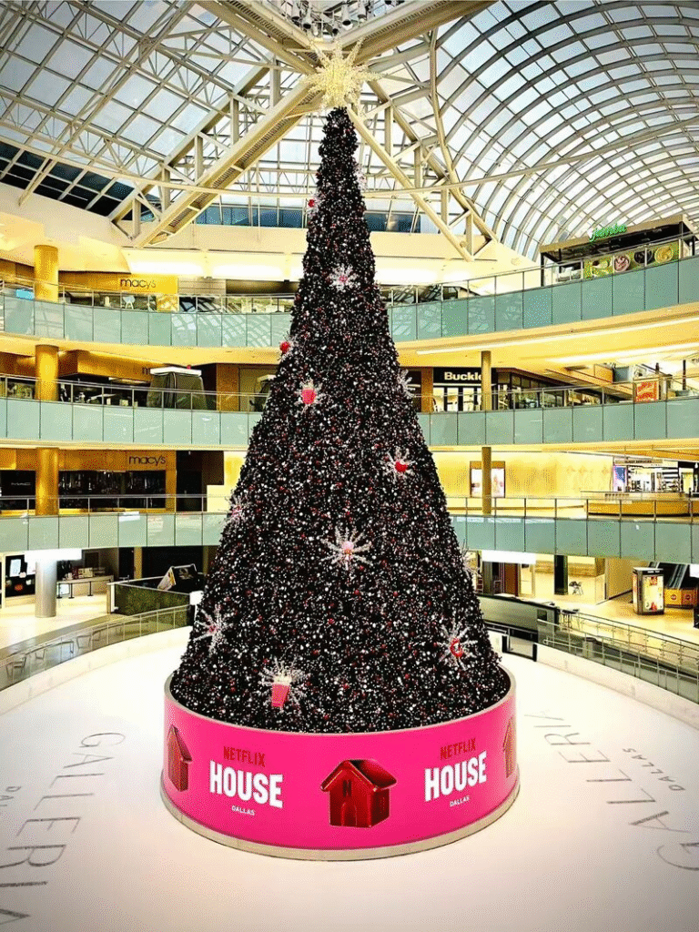 Completed Netflix House Dallas holiday installation with a 95ft Christmas tree, pink branded base, and custom ornaments.