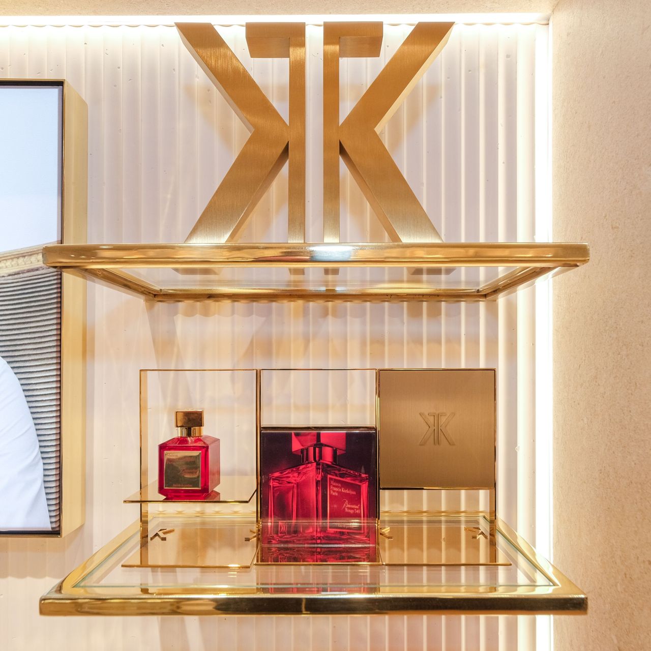 Close-up of illuminated shelving with brushed gold trim under department store lighting.