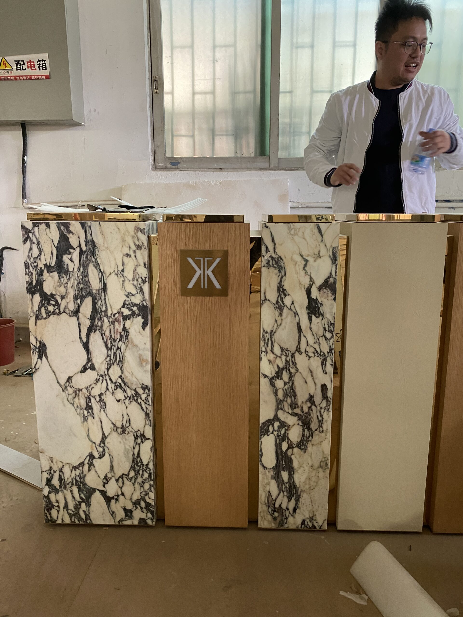 Stone and metal panel samples undergoing structural pre-assembly inspection at the factory before packaging.