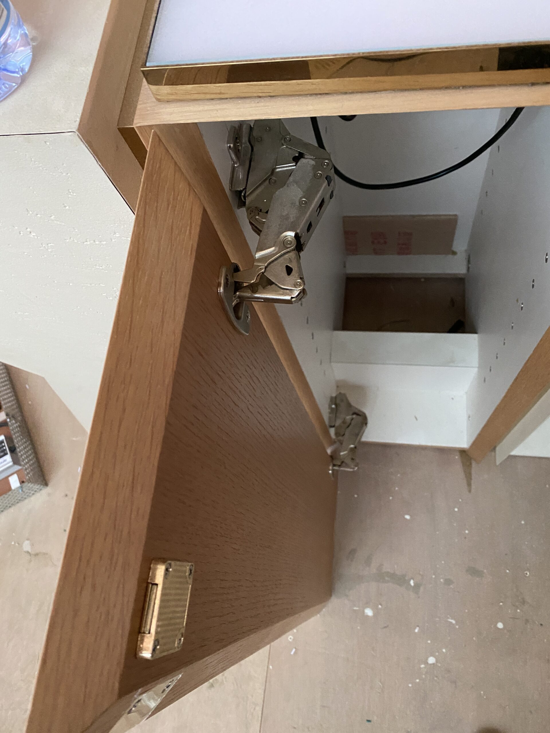 Heavy-duty wide-angle cabinet hinge installed on a storage door for daily retail use.