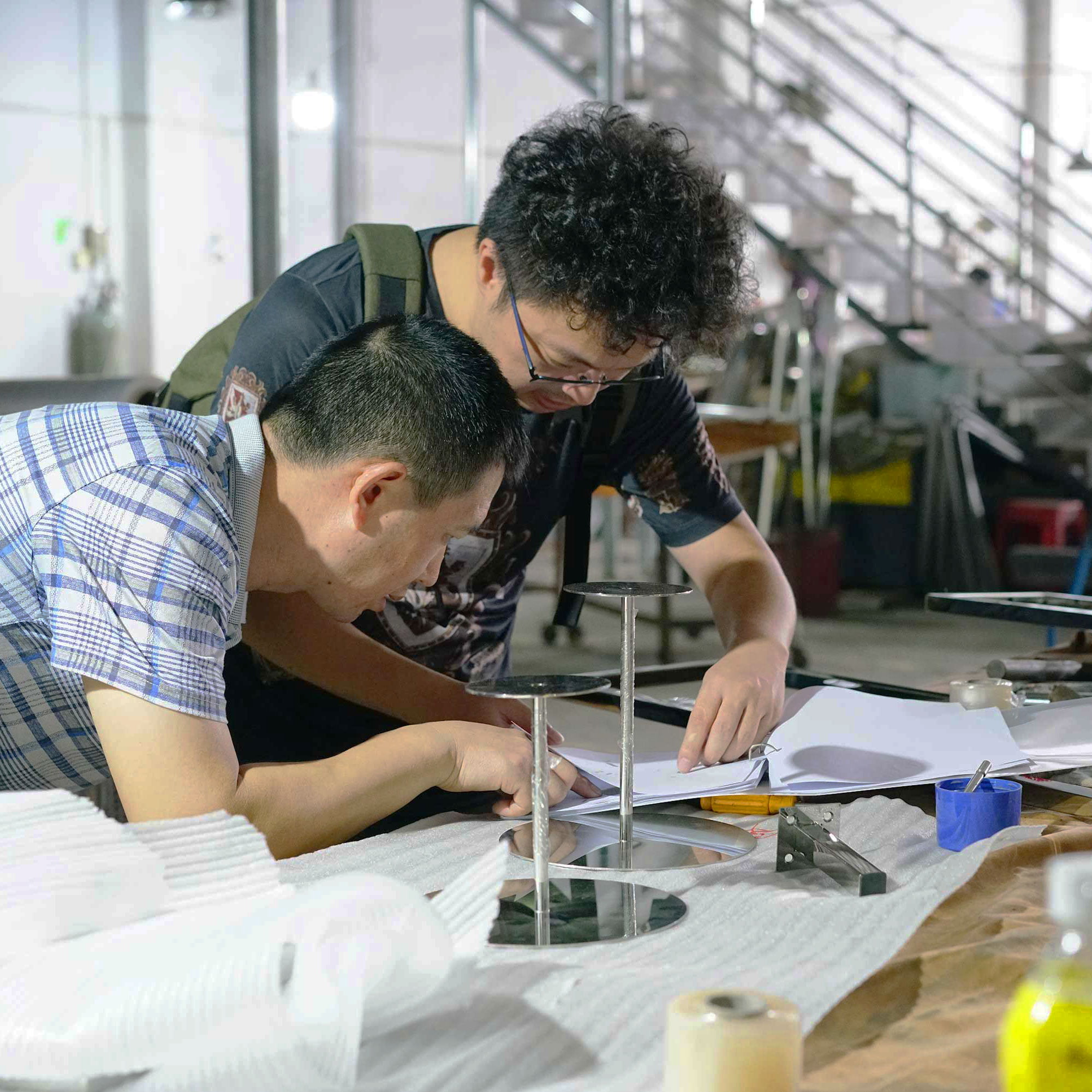 Factory technician inspecting metal riser frame.