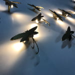 Custom illuminated dragonfly display props creating a warm lighting effect for luxury retail window displays