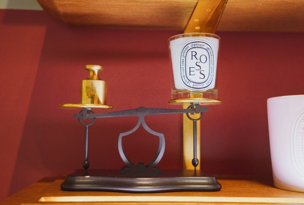 Custom perfume display stand with brass platform and black metal balance structure