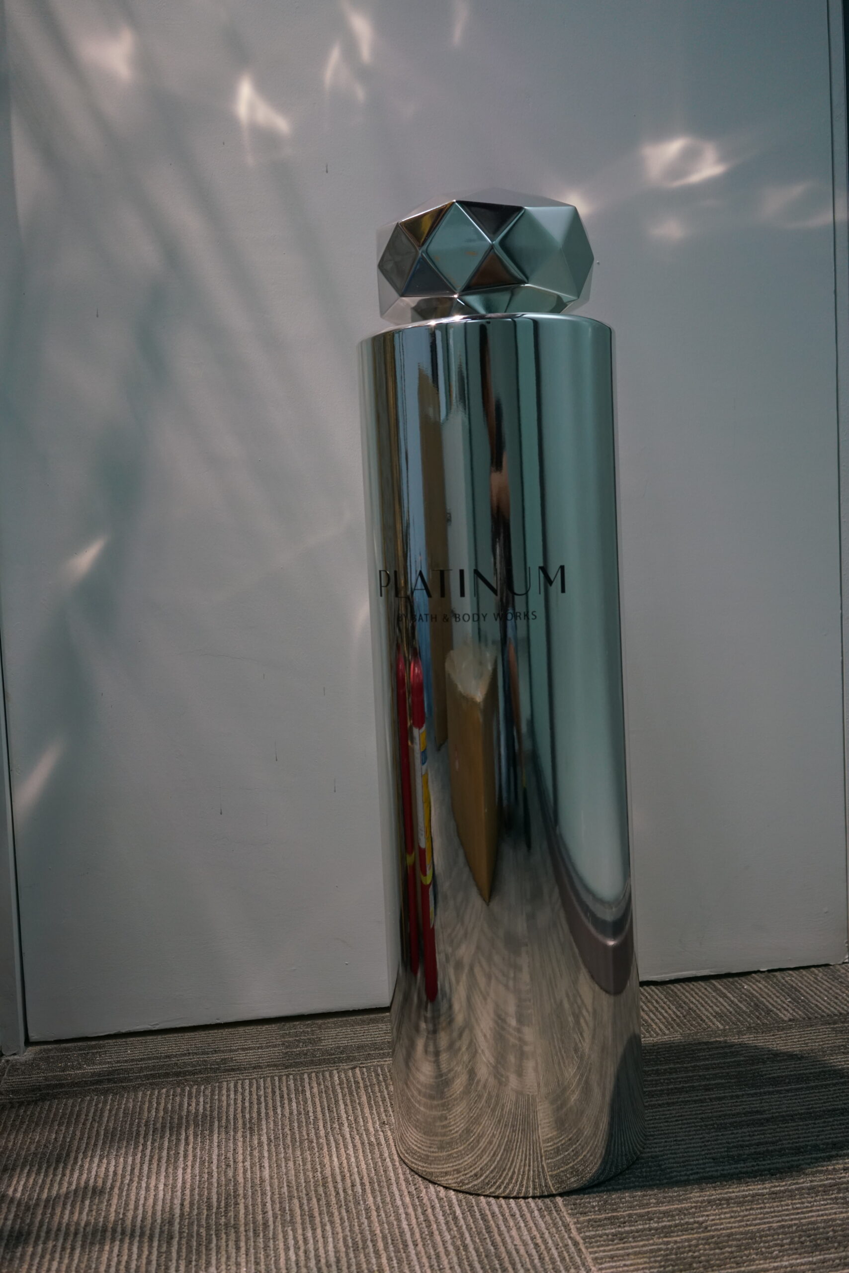Custom prop fabrication of an oversized mirror-finish perfume bottle display