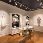 Custom metal display stands and gold-finished retail fixtures in a luxury fashion store