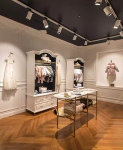 Custom metal display stands and gold-finished retail fixtures in a luxury fashion store