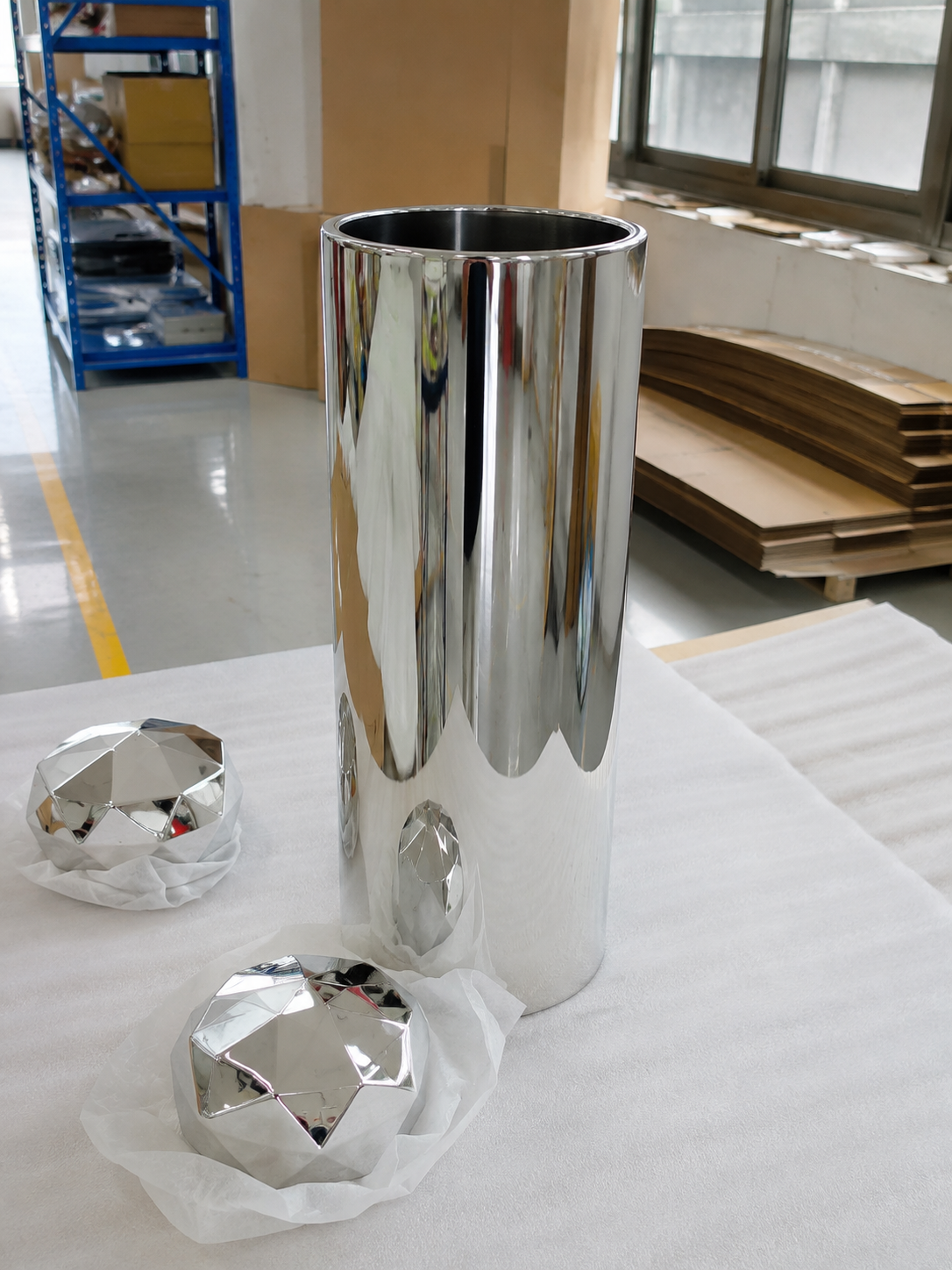 Reflective cylindrical display body with separate faceted cap components in the workshop