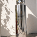 Custom giant perfume bottle display with chrome finish and faceted cap for retail visual merchandising