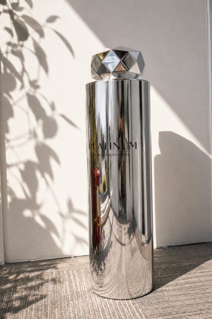 Custom giant perfume bottle display with chrome finish and faceted cap for retail visual merchandising