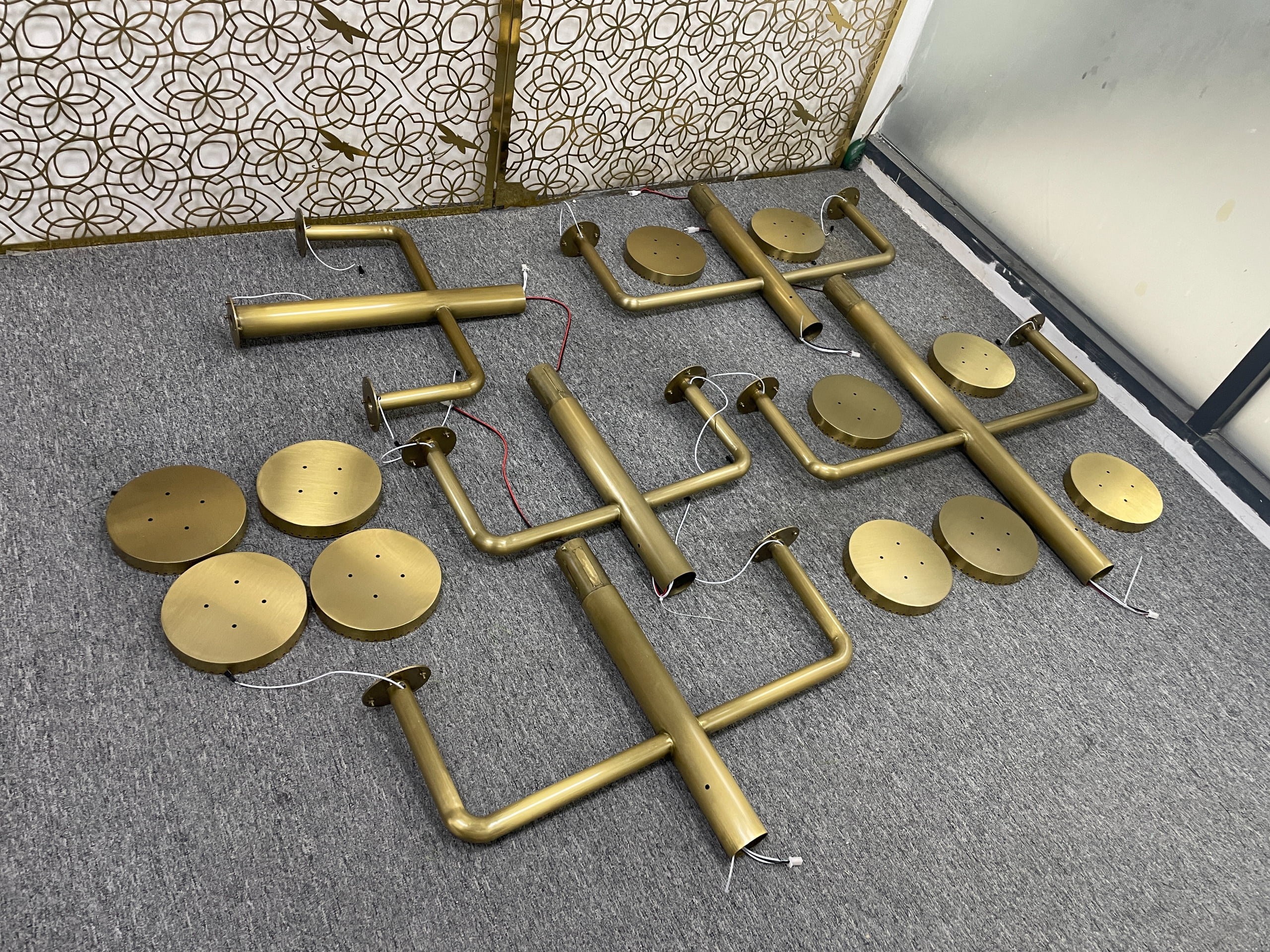 Disassembled christmas tree prop showing detachable gold-toned trunk sections, branches, wiring, and circular light housings.