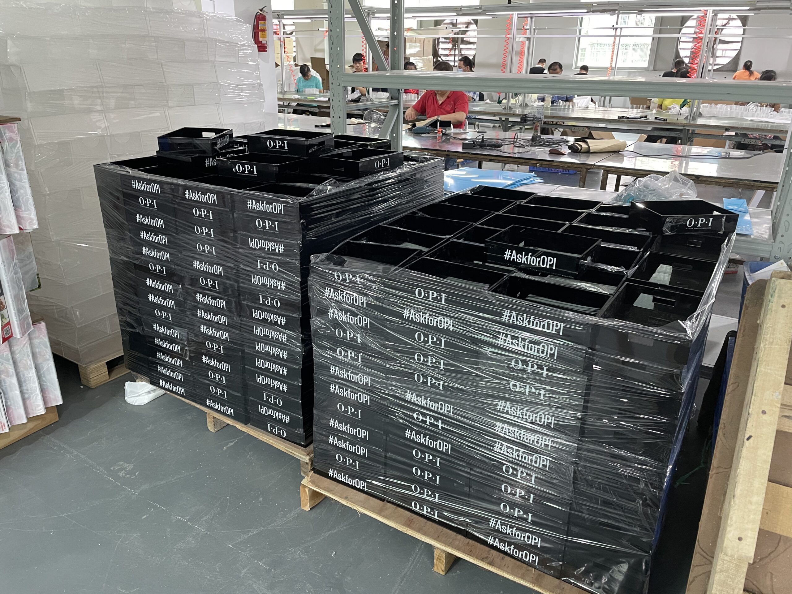Acrylic display tray mass production for OPI with finished units stacked and protected on pallets